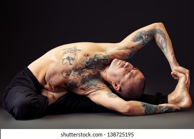 Handsome man shows different yoga exercises over black background.
