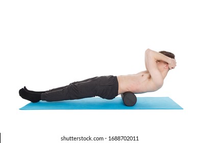 Handsome man shows exercises using a foam roller for a myofascial release massage of trigger points. Isolated on white.