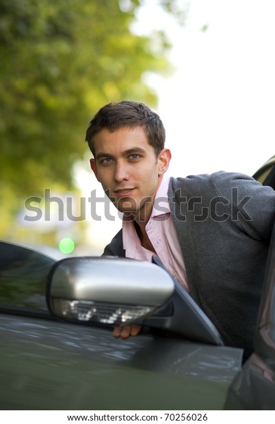 Handsome man sit down to his\
car