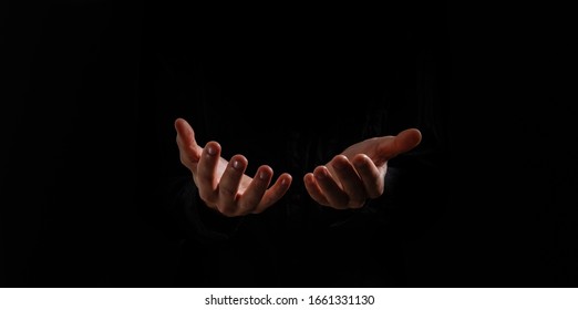 Handsome man sit prayer on black background. His hands are praying for God's blessings. - Shutterstock ID 1661331130