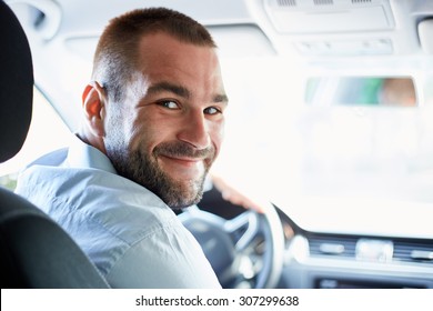 Handsome Man Sitting In A Car And Looking Back