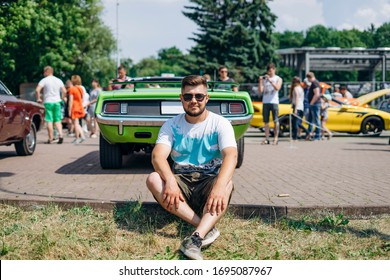 Handsome Man Sitting Near Muscle Car. Green Machine