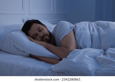 Handsome man sleeping in bed at night - Powered by Shutterstock