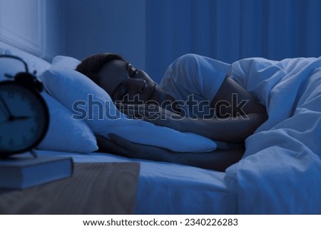 Handsome man sleeping in bed at night
