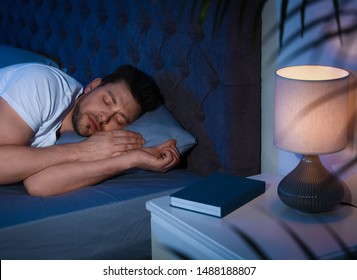 Handsome Man Sleeping On Pillow In Dark Room At Night. Bedtime