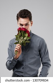 Handsome Man Smelling Bouquet Of Red Roses