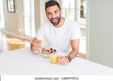 Handsome Man Smiling Eating Healthy Breakfast And Drinking Orange Juice In The Morning