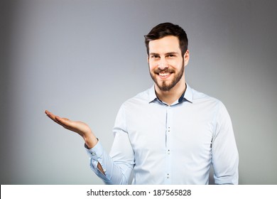 Handsome Man Smiling And Holding Something Imaginary In One Hand