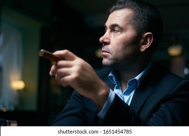 Handsome Man Smoking Cigar In A Lounge Bar