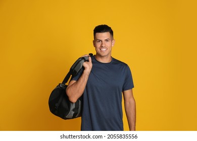 Handsome Man With Sports Bag On Yellow Background