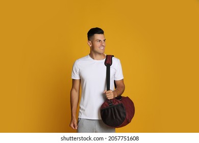 Handsome Man With Sports Bag On Yellow Background