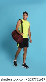 Handsome Man With Sports Bag On Light Blue Background