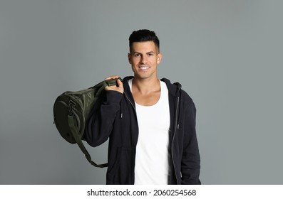 Handsome Man With Sports Bag On Grey Background