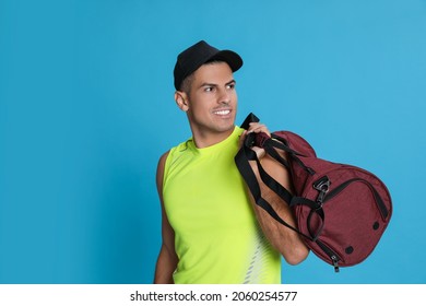 Handsome Man With Sports Bag On Light Blue Background