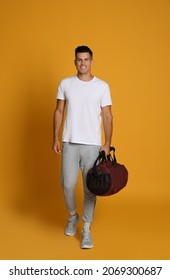 Handsome Man With Sports Bag On Yellow Background