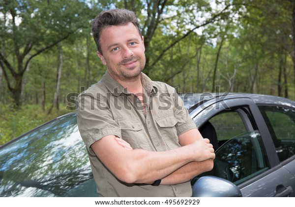 Handsome man\
standing in front of car\
smiling