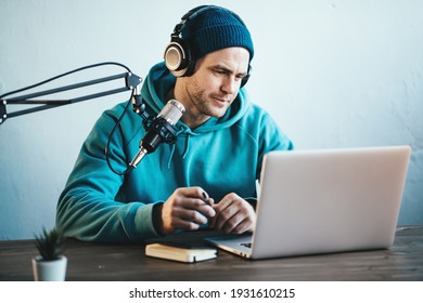 Handsome Man Streaming His Audio Podcast At Small And Cozy Home Broadcast Studio