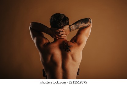 Handsome Man Streching With Tarantula On His Back At The Studio