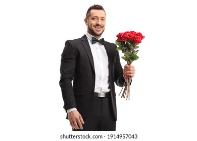 Handsome man in a suit holding a bunch of red roses isolated on white background
