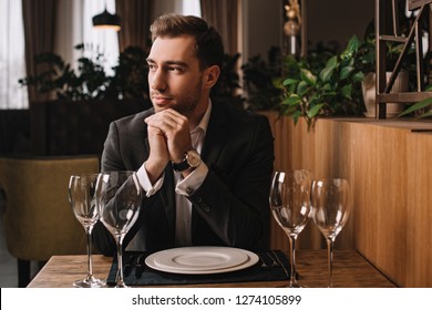 Handsome Man In Suit Waiting For Girlfriend In Restaurant