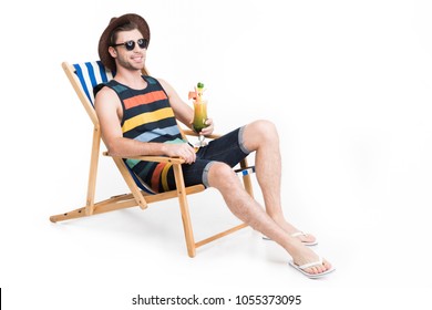 Handsome Man In Sunglasses And Hat Relaxing On Beach Chair With Cocktail, Isolated On White