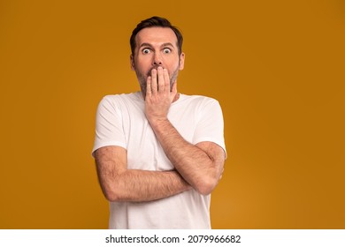 Handsome Man With Surprised Emotions On His Face Looking At The Camera. A Lot Of Copy Space. Facial Expressions Concept. Real People. Studio Shot.