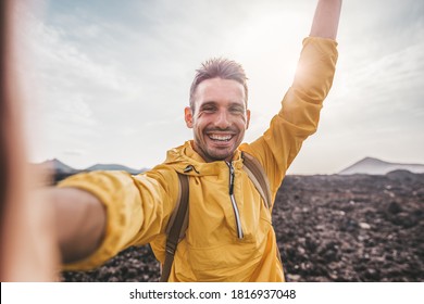 Handsome Man Taking A Selfie Climbing A Rock. Smiling Hiker Taking A Portrait With Action Cam Hiking A Mountain At Sunset.