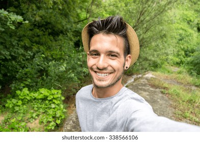 Handsome man is taking a selfie outdoor - caucasian people - nature, people, lifestyle and technology concept - Powered by Shutterstock