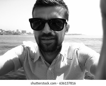 Handsome Man Taking Selfie.Close up portrait of man,man in sunglasses,stylish outfit,shirt,bearded man,man on the sea,relax,attractive,spring vacations,casual wear,happy face,pretty haircut,travel