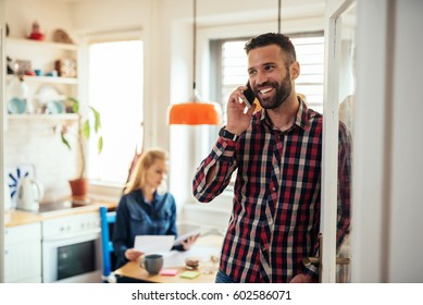 Handsome Man Talking On The Phone While At Home Working.