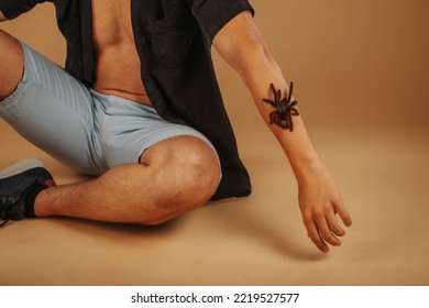 Handsome Man With Tarantula On His Hand Sitting At The Studio