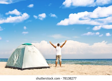 handsome man with tent enjoying camping recreation at a wonderful tranquil beach