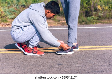 boy tying girl shoes