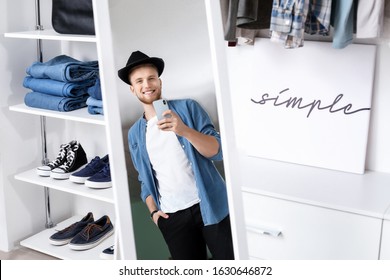 Handsome man trying on stylish clothes in dressing room