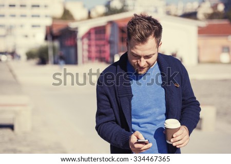handsome man is using an application in his smartphone device sending a text message