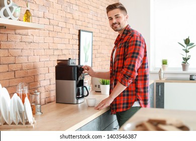 Handsome Man Using Coffee Machine In Kitchen