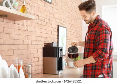 Handsome Man Using Coffee Machine In Kitchen