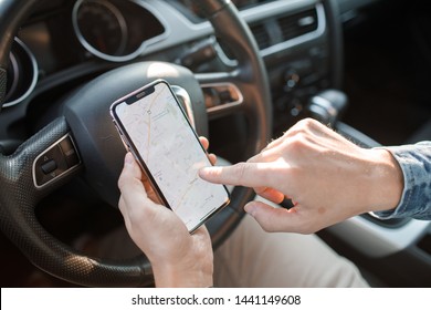 Handsome man using mobile phone while driving. Man driver using smart phone in car