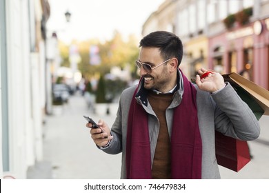 Handsome Man Using Phone During The Shopping