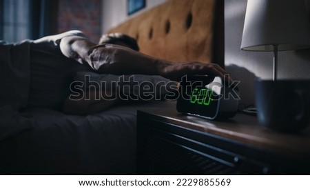 Handsome Man Wakes Up and Turns off Alarm Clock. Proceeds to Have a Productive Day of Work. Stylish Apartment. Focus on the Clock Showing Six O'Clock. Bedroom Apartment