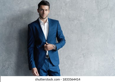 Handsome Man Wear Blue Suit Isolated On Grey Background.