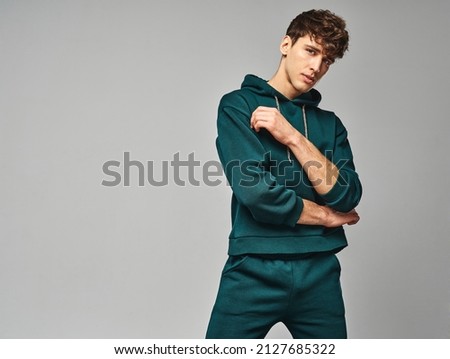 Handsome man wear of green set of track suit isolated on grayl background