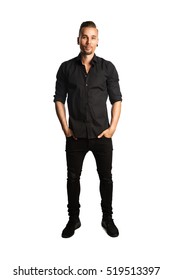 A Handsome Man Wearing Black Jeans And A Black Shirt Standing Against A White Background Smiling.