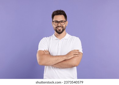 Handsome man wearing glasses on violet background