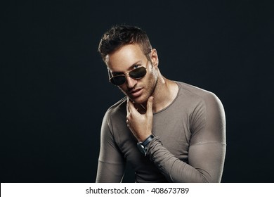 Handsome Man Wearing Sunglasses In The Studio On A Dark Background