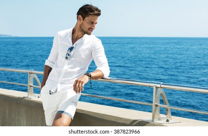 Handsome man wearing white clothes posing in sea scenery - Shutterstock ID 387823966
