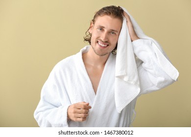 Handsome Man Wiping Hair After Washing Against Color Background