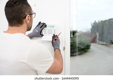 Handsome Man Worker Installing Alarm Technology Insurance In Home For Burglary Prevention