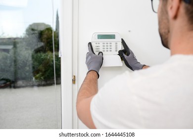 Handsome Man Worker Installing Alarm Technology Insurance In Home For Burglary Prevention