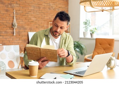 Handsome man working with notebook at table in office
